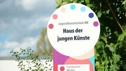 Auf einem bunten Eingangschild steht "Jugendkunstschule NB. Haus der jungen Künste". © Screenshot 