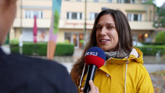 Eine Frau spricht auf der Straße in ein NDR Mikrofon. © Screenshot 