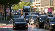 Mehrere Fahrzeuge auf einer gefüllten Straße. © Screenshot 