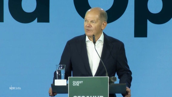 Kanzler Scholz steht am Rednerpult. © Screenshot 