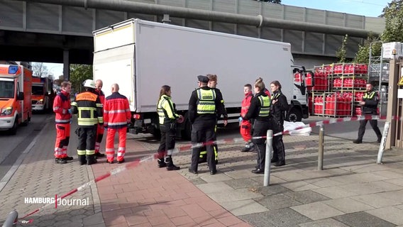 Rettungskräfte stehen vor einem weißen Lkw. © Screenshot 