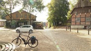 Ein idyllischer Dorfplatz. © Screenshot 