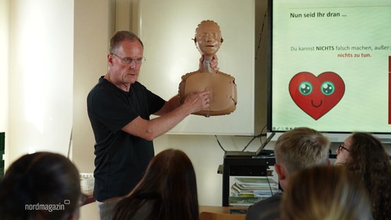 Bernd Müllejans gibt einen Reanimations-Kurs an einer Schule. © Screenshot 