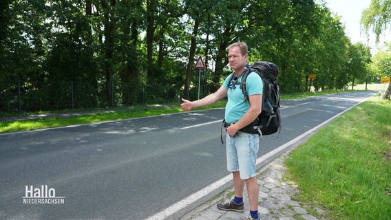 Thilo Tautz steht an einer Straße und trampt. © Screenshot 