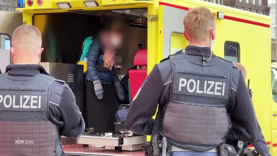 Polizisten vor einem Rettungswagen am Hamburger Hauptbahnhof. © Screenshot 