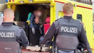 Polizisten vor einem Rettungswagen am Hamburger Hauptbahnhof. © Screenshot 