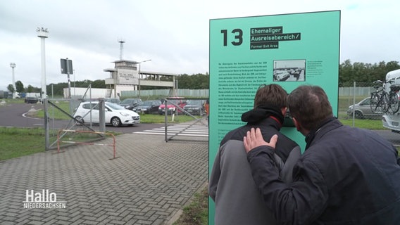 Zwei menschen schauen gemeinsam auf eine Infotafel. © Screenshot 