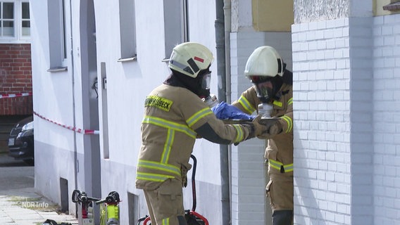 Einsatzkräfte tragen Gegenstände aus dem Haus. © Screenshot 