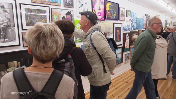 Besucher betrachten die Bilder der Ausstellung. © Screenshot 