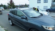 Ein Polizist kontrolliert ein Auto in Norderstedt. © Screenshot 