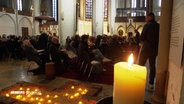 Eine Kerze brennt in der St. Petri Kirche als Erinnerung an den 7. Oktober. © Screenshot 