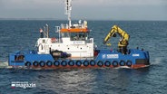 Ein Schiff mit einem Greifarm fährt auf der Ostsee. © Screenshot 