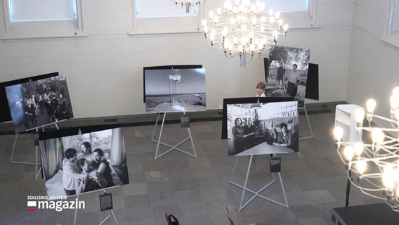 Viele Schwarz-Weiß Fotografien stehen in einer Ausstellung. © Screenshot 