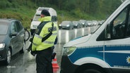 Ein Beamter der Bundespolizei kontrolliert Fahrzeuge an der dänischen Grenze bei der Einreise nach Deutschland. © Screenshot 