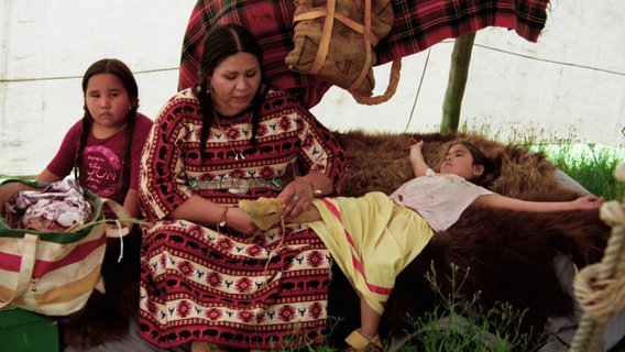 Angehörige der First Nations Blackfoot sitzen in einem Zelt. © Screenshot 