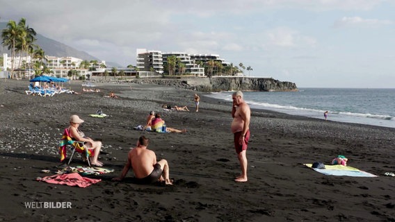 Touristen am schwarzen Sandstrand von La Palma. © Screenshot 