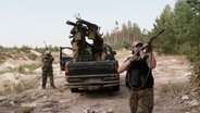 Ukrainische Frauen mit Gewehr im Anschlag und auf einem Militärfahrzeug. © Screenshot 