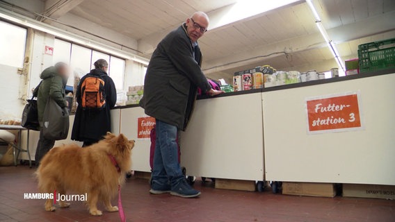 Ein Mann und seinHund stehen an der Futterausgabe der Hamburger Tiertafel . © Screenshot 