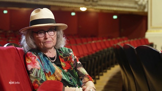 Anna Haase berichtet in einem Theater sitzend über ihr Leben in der DDR. © Screenshot 