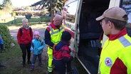 Einsatzkräfte helfen Kindern in einen Rettungswagen. © Screenshot 