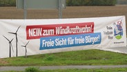 Ein banner mit der Aufschrift: "NEIN zum Windkraftwahn! - Freie Sicht für freie Bürger!". © Screenshot 