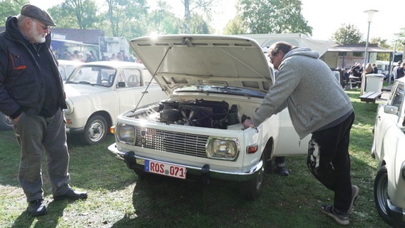 Zwei Männer begutachten einen Oldtimer. © Screenshot 