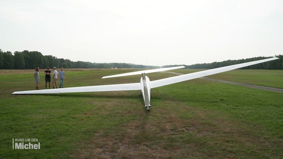 Ein Segelflugzeug liegt auf einer Wiese. © Screenshot 