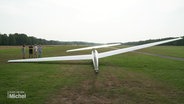 Ein Segelflugzeug liegt auf einer Wiese. © Screenshot 