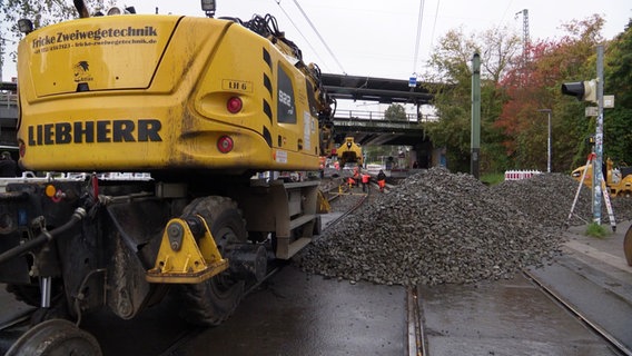 Bauarbeiter führen Sanierungsarbeiten an einer Straßenbahnstrecke in Rostock durch. © Screenshot 