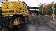 Bauarbeiter führen Sanierungsarbeiten an einer Straßenbahnstrecke in Rostock durch. © Screenshot 