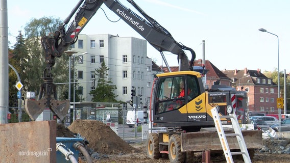 Ein Bagger steht auf einer Baustelle und gräbt ein Loch. © Screenshot 