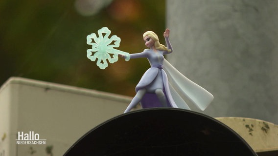 Eine Playmobilfigur von "Elsa" aus dem Disneyfilm Frozen steht auf einer Fußgängerampel. © Screenshot 