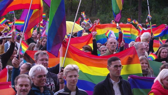 Demonstrierende mit Regenbogenflaggen vor dem Rathaus in Neubrandenburg. © Screenshot 