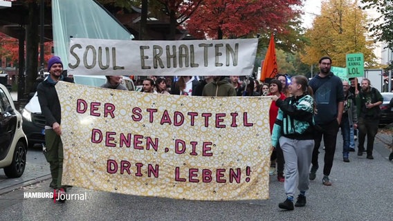 "Der Stadtteil denen, die hier leben" steht auf einem Banner bei einer Demo in Hamburg-Wilhelmsburg für den Erhalt der Fabrikhalle "Soul Kitchen". © Screenshot 