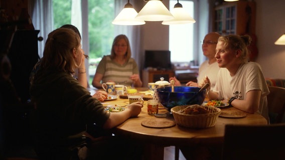 Pastorin Ina Jäckel spricht mit Menschen, die im Wohnprojekt Allmende Wulfsdorf bei Ahrensburg ein Zuhause gefunden haben. © Screenshot 