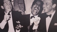 Ein berühmtes Foto zeigt Dean Martin, Sammy Davis Jr. und Frank Sinatra rauchend und lachend. © Screenshot 