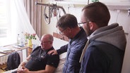 Michael Hoppe von der Freiwilligen Feuerwehr Waren wird im Krankenhaus von Kollegen besucht. © Screenshot 