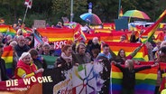 Demonstranten protestieren gegen das Verbot der Regenbogen-Flagge vorm Bahnhof von Neubrandenburg. © Screenshot 