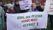 Protestierende halten Banner in den Händen. © Screenshot 