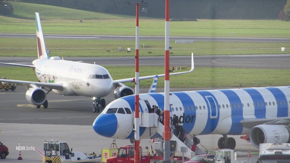 Zwei Flugzeuge stehen auf der Landebahn vom Hamburger Flughafen. © Screenshot 