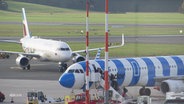 Zwei Flugzeuge stehen auf der Landebahn vom Hamburger Flughafen. © Screenshot 