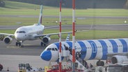 Zwei Flugzeuge stehen auf der Landebahn am Hamburger Flughafen. © Screenshot 