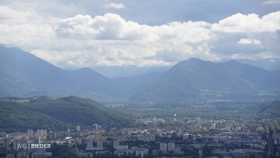 Blick auf eine in einem Alpental gelegene Stadt © Screenshot 