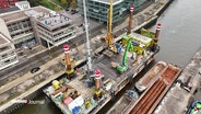 Vogelperspektive des Schwimm- und Arbeitspontons bei Bauarbeiten an der Kaimauer "Westkai" in Neumühlen. © Screenshot 