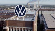 Ein großes VW-Logo steht auf einem Fabrikgebäude. © Screenshot 