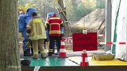 Einsatzkräfte der Feuerwehr und des Kampfmittelräumdienstes bergen die mit Chemikalien kontaminierten Kartuschen. © Screenshot 