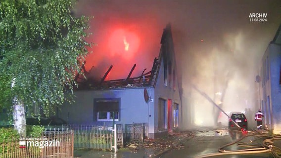 Das Dachgeschoss eines Wohnhauses ist bis auf die Dachbalken abgebrannt, dichter Rauch steigt auf. Feuerwehrleute bei Löscharbeiten. (Archivbild) © Screenshot 