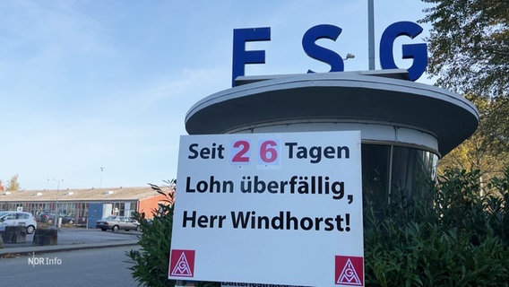 Das Logo der Werft FSG, darunter ein Plakat: "Seit 26 Tagen überfällig, Herr Windhorst!" © Screenshot 