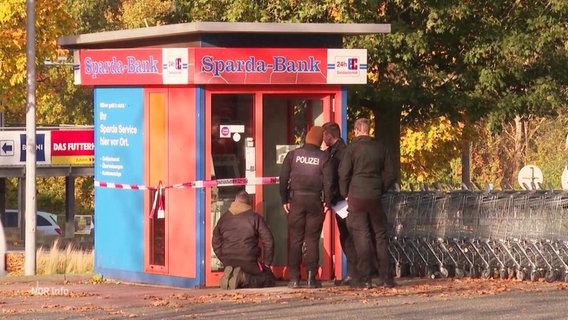 Polizeibeamte untersuchen den explodierten Geldautomaten in Wedel. © Screenshot 