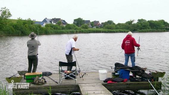 Drei Männer stehen auf einem Steg an einem See und werfen ihre Angeln aus. © Screenshot 